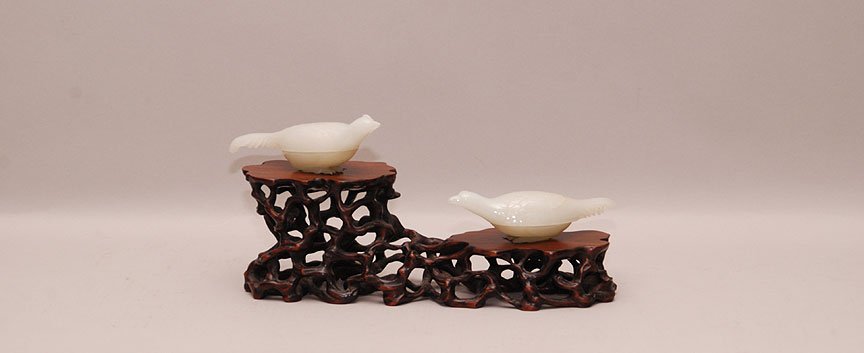 Pair Carved White Jade Bird Form Boxes. With custom fi: Pair Carved White Jade Bird Form Boxes. With custom fitted carved wood root form stand. Condition: multiple losses to the carved feet. Minor roughness to rims of the bases and minor loss to one tail. 