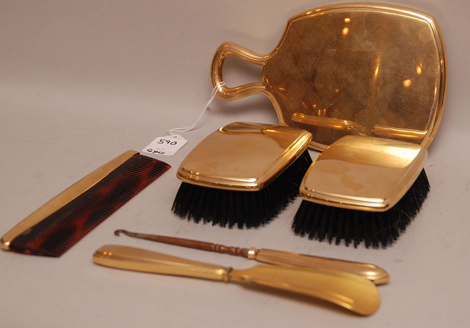 Six Piece Assembled 14K Gold Dresser Set consisting of : Six Piece Assembled 14K Gold Dresser Set consisting of one hand mirror, two brushes, one comb, one show horn and one button hook. Condition: minor normal wear. Mirror 8" x 5"