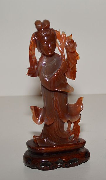 Chinese Carnelian Quan Yin mounted on a custom wood: Chinese Carnelian Quan Yin mounted on a custom wood base. Ht. 6 1/4"