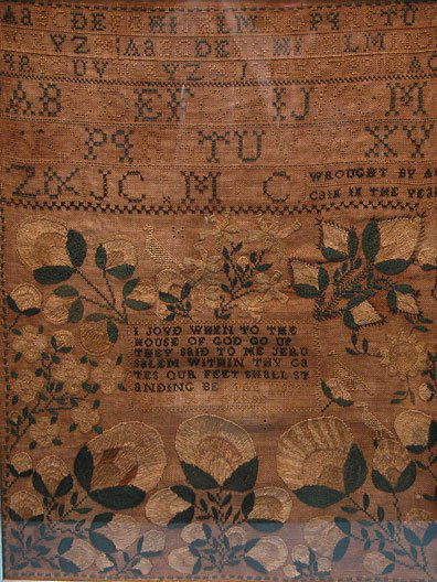 Framed needlework antique sample: Framed needlework antique sampler, 16"x12", decorated with flowers, under glass, worn and discolored; wrought by Ann (or Ain) Cain in the year 1832, it reads: I joyd when the house of God go up they s