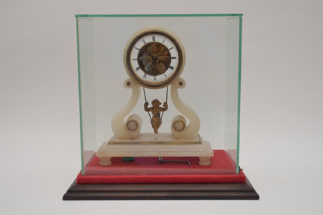 Antique Alabaster Clock with swinging child pendulum.: Antique Alabaster Clock with swinging child pendulum. The white enamel dial centered by a open escapement. Ht. 9 ¼”