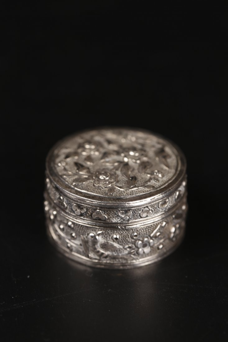 A Silver Tobacco Paste Container: This is a Republic Period silver lidded container. It is designed for opium paste or other kinds of tobacco. Overall incised with floral patterns. H: 1.7cm. Dia: 3cm. Wt: 77g. 民国银