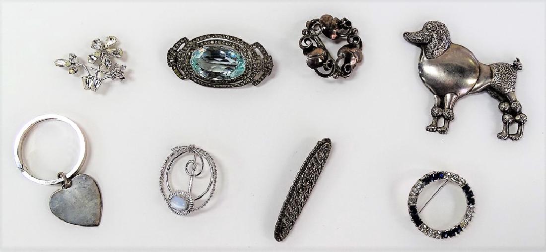 LOT OF STERLING JEWELRY: To include a poodle pin, a faux topez pin, a Lenour Deskow sterling heart keychain, two round broaches, a sterling pin, and two small sterling pins (total weight = 46 g). Shipping to be $15 plus insur