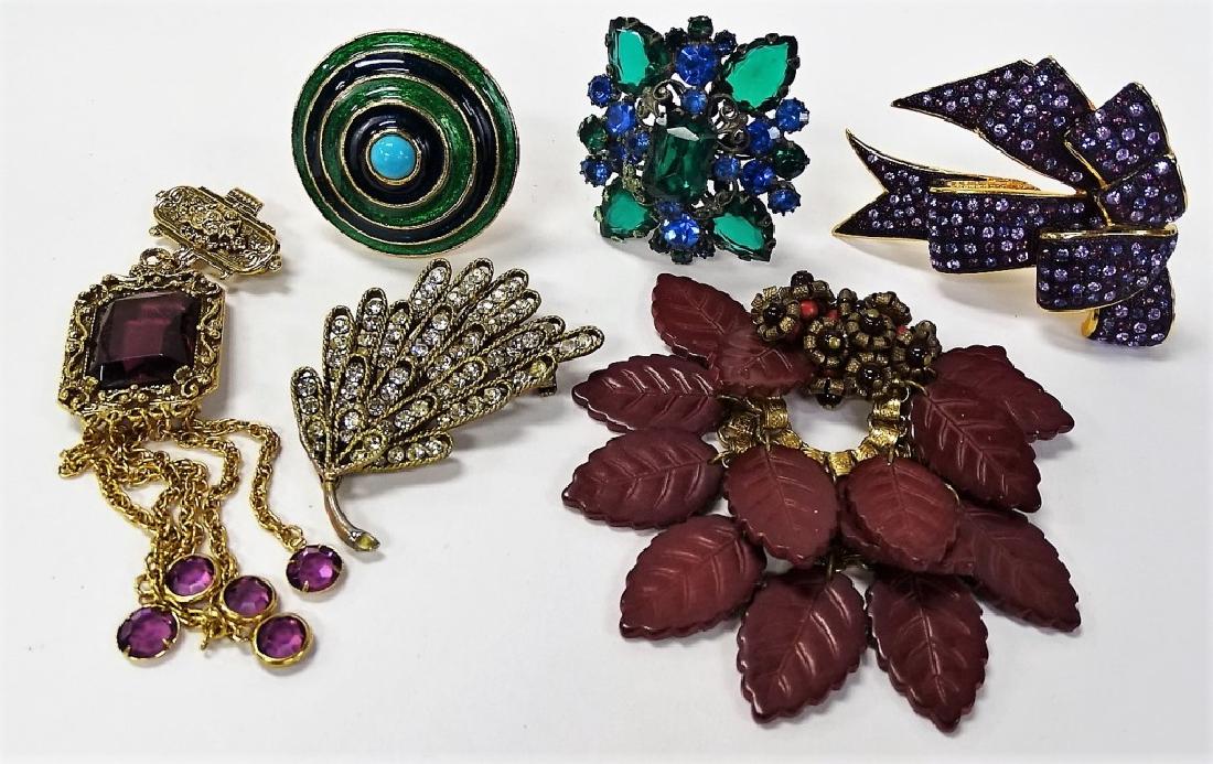 LARGE LOT OF COSTUME JEWELRY: To include a large Har marcasite pin, an antique Czech faux jeweled broach, a Joan Rivers gold tone and purple rhinestone broach, a Florenza gold tone and enameled broach, a gold tone and plastic Czec
