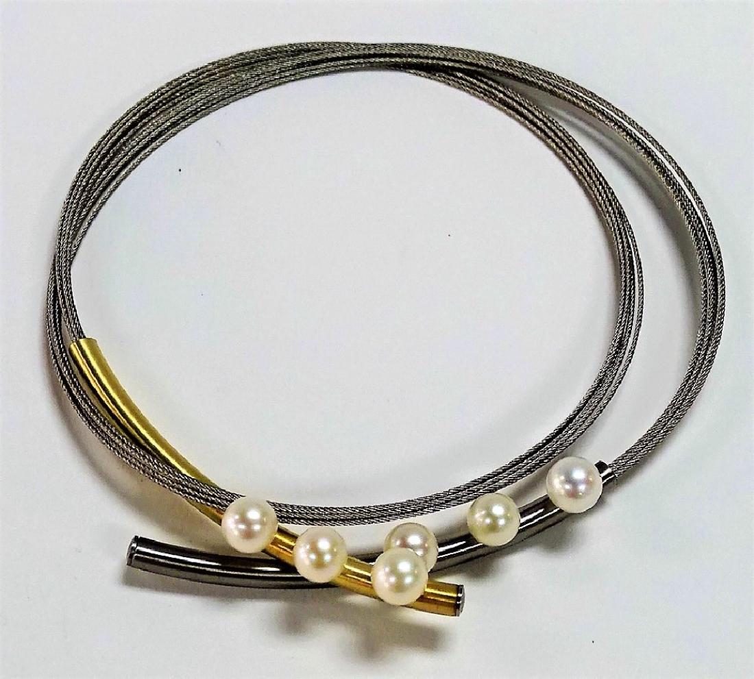CONTEMPORARY STAINLESS & CULUTRED PEARL NECKLACE: Contemporary style Stainless Steel & Pearl choker necklace. Comprised of a seven strand Stainless Steel cable strap fit with brushed Stainless and Goldplate caps with magnetic closure. Mounted with si