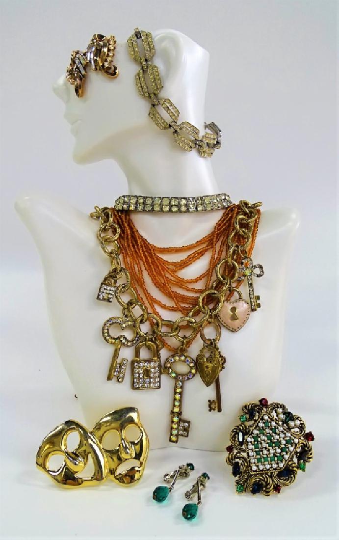 LARGE LOT OF COSTUME JEWELRY: To include a gold tone laugh now cry later pin, a silver tone w/ marcasite bracelet, a silver tone w/ rhinestone double line bracelet, a pair of Trifari gold tone w/ marcasite earrings, a vintage Art