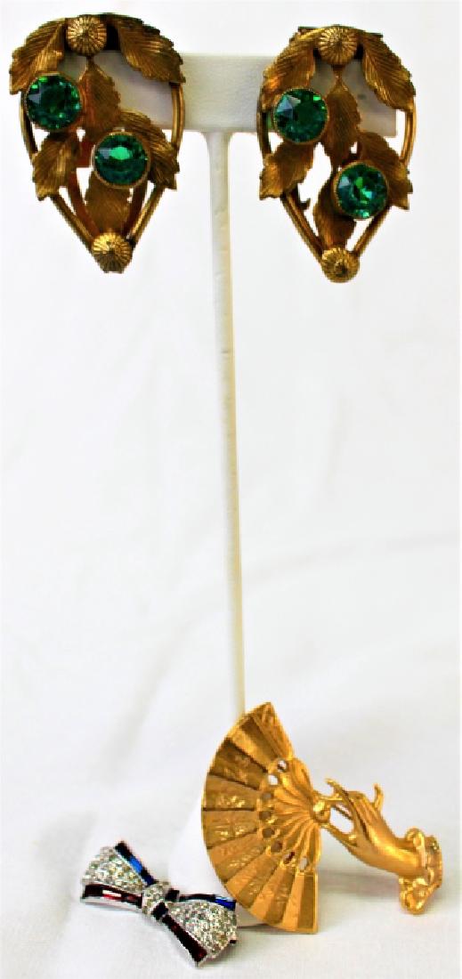 SIGNED AND UNSIGNED LOT OF COSTUME PINS / CLIPS: To include a Trifari Philippe red and white rhinestone pin, a VFJ 1999 hand holding fan pin, and a pair of Czech matching green stone fur clips.