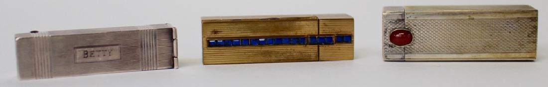 LOT OF VINTAGE LIPSTICK HOLDERS: To include an English silver w/ carnelian lipstick holder, a sterling lipstick holder signed "Betty", and an Elizabeth Arden of New York blue rhinestone lipstick holder. Shipping to be $15 US. We will
