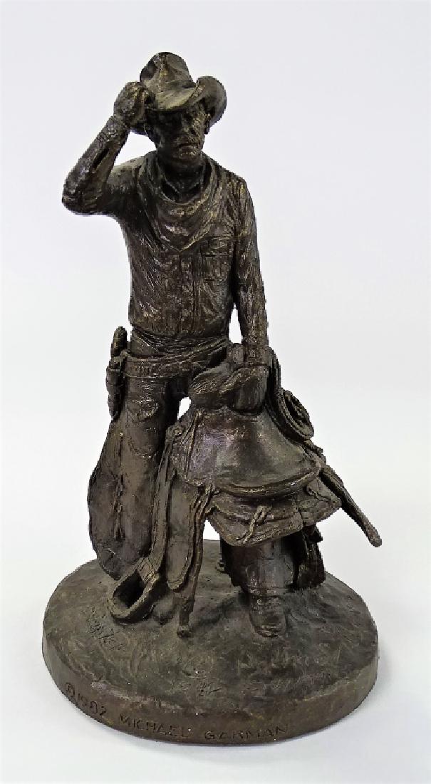 MICHAEL GODARD 1941 SPELTER COWBOY FIGURINE: Measures 10 1/2" tall, depicting a cowboy holding a saddle, dated and signed , very good condition we will not ship can refer local shippers