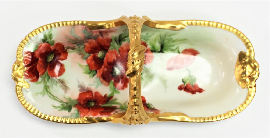 HAND PAINTED T&V LIMOGES PORCELAIN HANDLED BOWL: Antique Tresseman and Vogt Limoges porcelain handled bowl, with hand-painted floral motif, gilt decorated rim and handle. Artist signature "C. Hawes" to bottom. Measures approx. 5-1/4"H x 13-1/2"L x 6