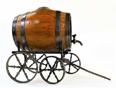 19TH CENTURY FRENCH OAK WINE CASK ON CARRIAGE: Late 19th century oak wine cask with fine silverplate banding, having a threaded spout and applied monogram decoration. Mounted atop a silver plate carriage, with four ornate six-spoked wheels done