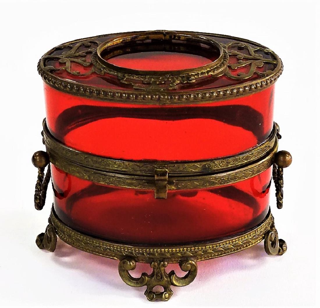 ANTIQUE FRENCH RUBY MOUNTED LADIES DRESSER BOX: Victorian, stands 3 1/2" tall x 4" wide. Dark ruby colored glass. This bob is mounted in a brass ormolu stand and is in excellent condition. We will not ship, can refer local shippers.