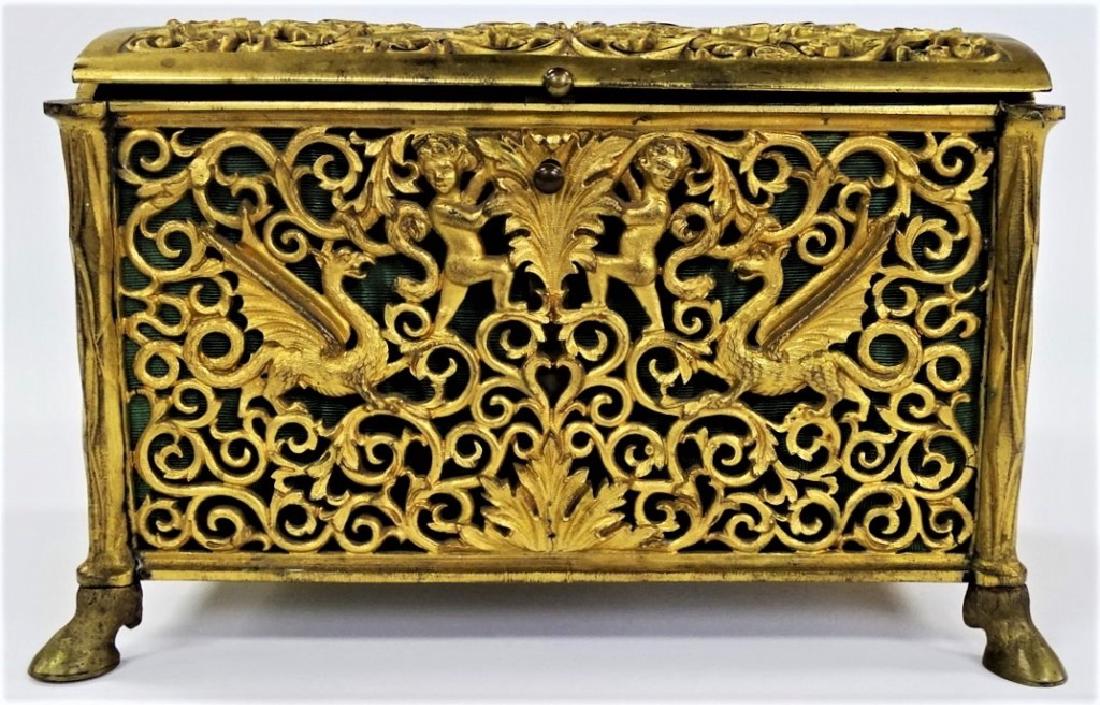 ANTIQUE FRENCH ORMOLU BRONZE JEWELRY CHEST: Mid 19th century French ormolu bronze jewelry casket, of hinged design. Having intricate scrolled open work design with sparse depictions of Chimera and Putti figures, riased on four hooved feet. Havi