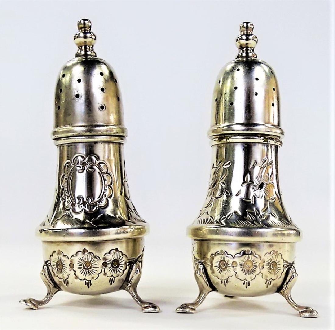 PR OF ANTIQUE B&M HAND CHASED STERLING SHAKERS: Pair of early 20th century Baldwin & Miller Inc. sterling silver shakers, hand chased with repousse floral motif, raised on three hooved feet. Made circa 1920. Combined total weight is approx. 2.75 oz