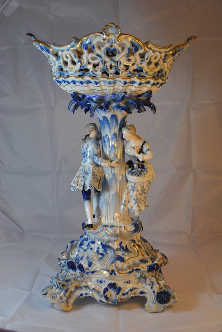 HUGE ANTIQUE MEISSEN FIGURAL COMPOTE WITH BASE: Turn of the century, predominant colors blue, white and gold, bears the large cross swords under glaze to base, depicts lovers holding hands around a tree, beautiful reticulate basket to top, measures