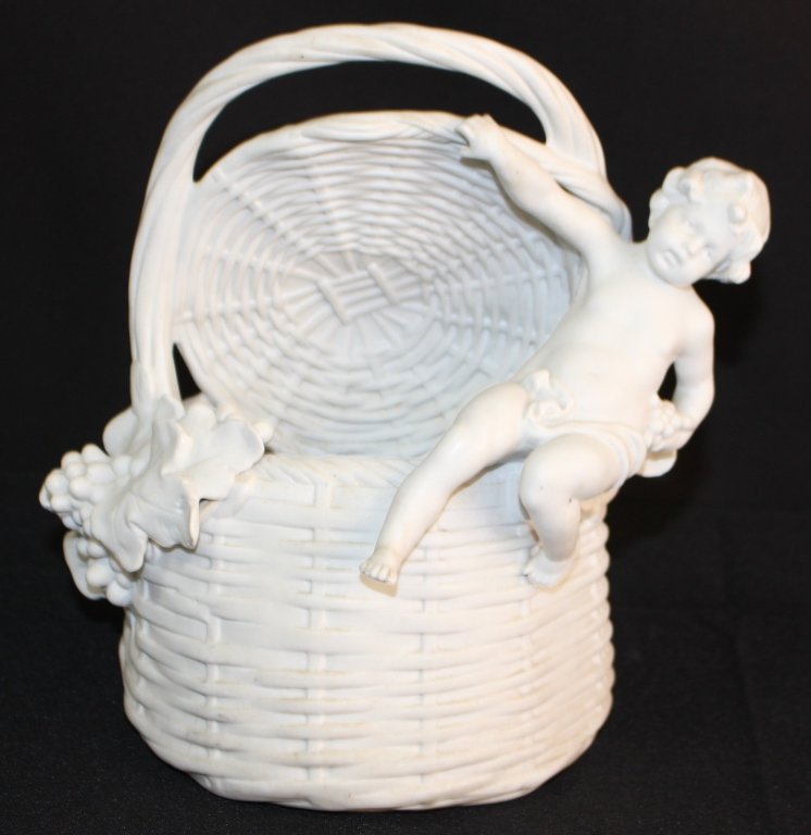 ANTIQUE PARIAN OF CHERUB SITTING ON A BASKET: Beautiful Parian cherub sitting on a basket that is decorated with grapes and grape vines. Measures approx 9" tall. Will ship for $40 U.S. plus insurance.