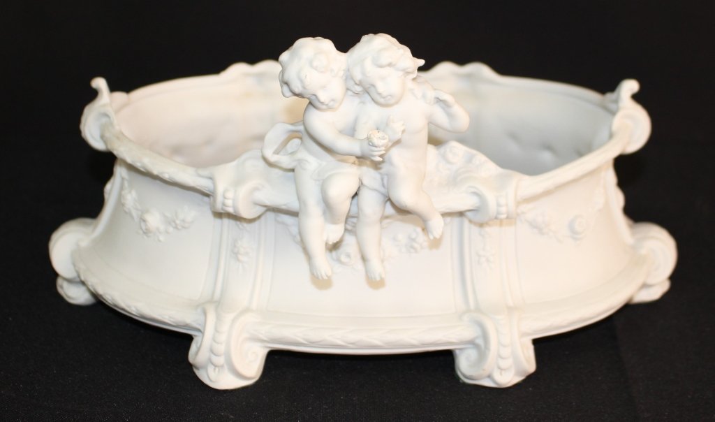 PARIAN ANTIQUE BOWL WITH TWO CHERUBS: Antique Parian high relief bowl with 2 cherubs side by side sharing a drink beautifully decorated with flowers through out numbered to bottom 2668. Measures approx 6" tall x 11" long. Will ship for $4
