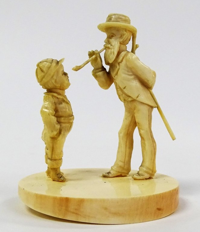 ANTIQUE CONTINENTAL CARVED IVORY MAN & BOY GROUP: A finely carved 19th/20th century continental Ivory group depicting an elderly traveler smoking a pipe and conversing with young boy. Mounted on sliced Ivory Tusk base. Unsigned. Measures approx. 2 3/
