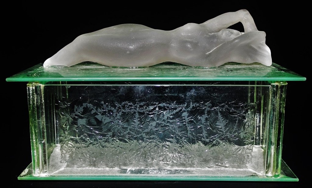 VINTAGE AM. FROSTED & ETCHED GLASS DRESSER BOX: Vintage American molded & frosted reclining figure of a nude female affixed to etched floriate glass cover, atop rectangular shaped beveled glass box. Unsigned. Measures approx. 9" length x 3" width x