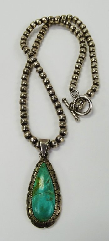 VTG NAVAJO STERLING & TURQUOISE PENDANT NECKLACE: Vintage Navajo Sterling Silver bead necklace adorned with Sterling framed Tear Drop shaped Turquoise stone pendant. Pendant bail marked 925. Necklace length of 10 3/4" length. Weighs approx. 38.5 gram