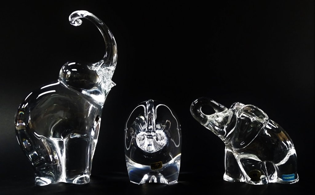 3 CRYSTAL GLASS TRUNK UP ELEPHANTS: 3 crystal glass elephants (1) Kosta Boda (2) Orrefors (3) Reijmyre elephant. Tallest measures approx 4" tall smallest approx 3" tall. Will not ship can refer local shippers.