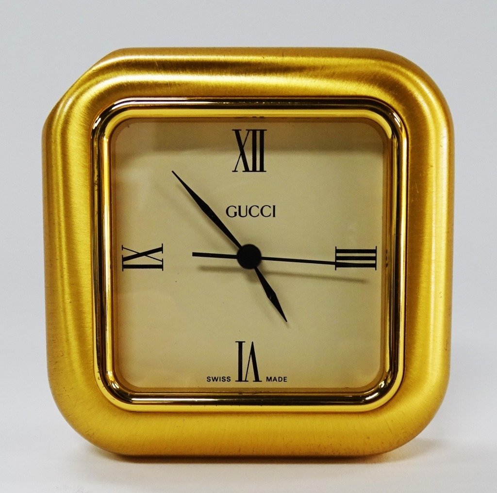 SMALL GUCCI TRAVELING CLOCK SWISS MADE GOLD TONE: Gucci traveling clock with a gold tone Swiss made, Measures approx 3 1/2" tall. Will ship for $25 U.S. plus insurance.