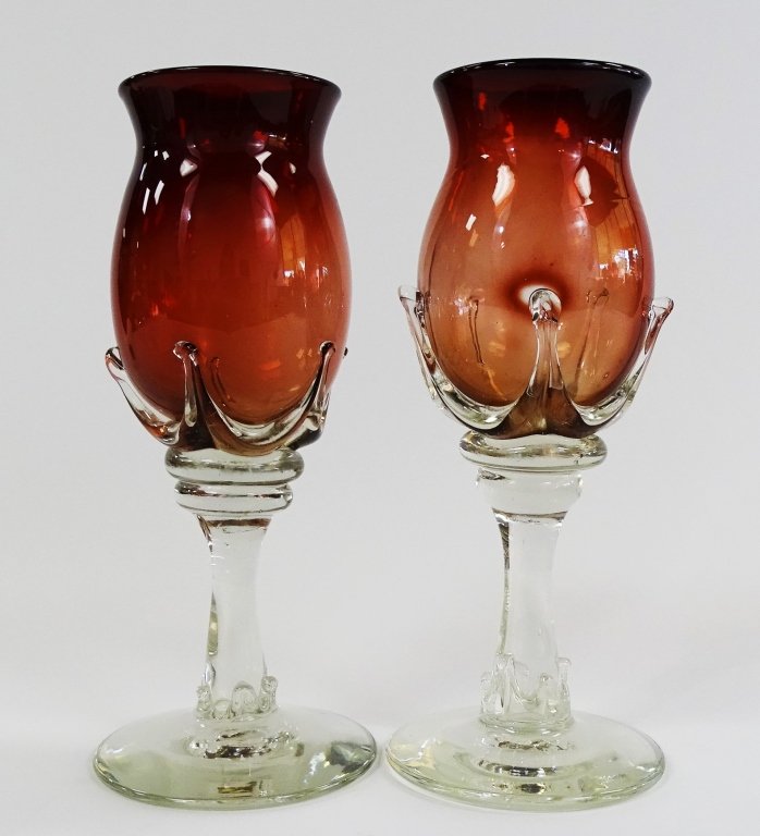 PR ROBERT DEEBLE HAND BLOWN ART GLASS WINE GOBLETS: Pair of Robert Deeble hand blown art glass stemware wine goblets. Designed with red colored cups applied to clear colored stems. Etched "Deeble" to underside. Each measures approx. 9" H. Will not ship
