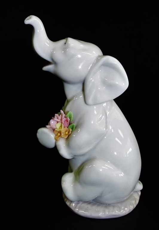 LLADRO PORCELAIN TRUNK UP 'LUCY IN LOVE' #6462: Lladro porcelain "LUCKY IN LOVE" # 6462 - Elephant with Flowers sculptor is Juan Huerta. Measures approx 5 ' tall. Will not ship can refer local shippers.