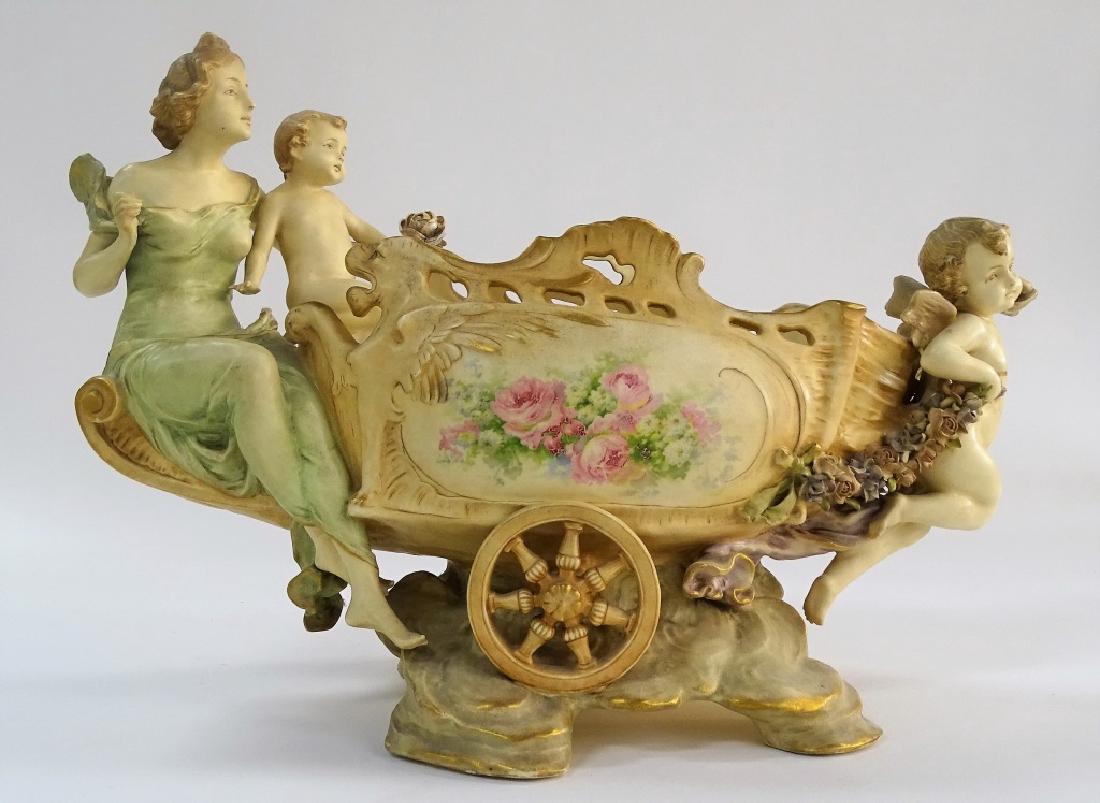 ANTIQUE PORCELAIN MOTHER W/CHERUB WHEEL BARREL: Antique porcelain hand painted of a mother and cherubs pushing a wheel barrel decorated with nice scroll and foliage. Measures approx 12' tall x 17 ' long. Will not ship can refer local shippers.