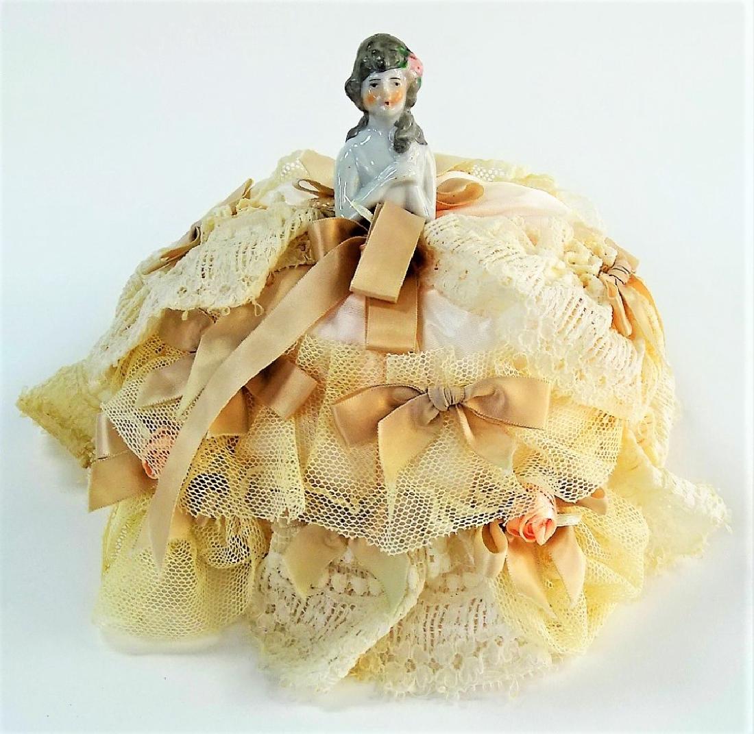 HALF DOLL PORCELAIN PIN CUSHION: A beautiful large sized hand painted half doll or a pin cushion doll. She is delicately hand painted and her face is very sweet. Her hair style appears to be from the 1700s style. Measures approx 7' t