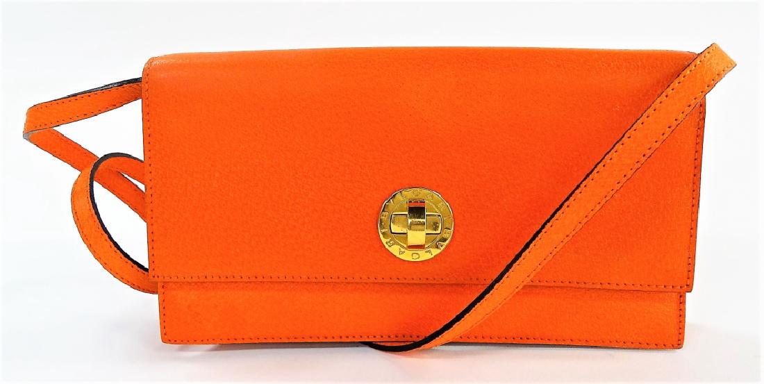 BVLGARI DESIGNER ORANGE PIGSKIN CONVERTIBLE CLUTCH: Ladie's desginer convertible clutch handbag by Bvlgari. Done in holiday orange colored Pigskin Leather, with gold tone hardware and clasp. Front flap closure opening to black fabric lined interiro wit