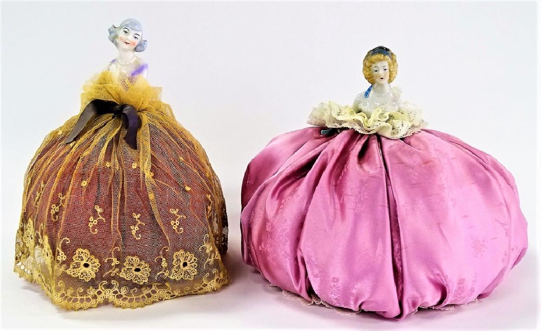 PAIR OF PORCELAIN WOMAN PIN CUSHIONS: Pair of porcelain woman pin cushions. Measures approx 8 1/2' tall. Will not ship can refer local shippers.