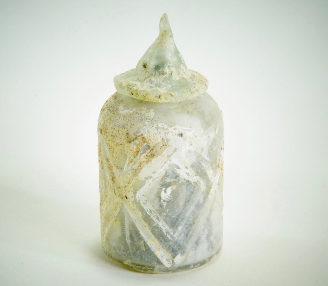 A Byzantine Lidded Glass Pyxis: Byzantine, ca. 6th-7th Century A.D. Dimensions: Height 3 1/2 in. (8.9 cm.), 2 1/4 (5.7 cm.) (without lid) Provenance: Ex- Netherlands private collection, 1988. Condition Report: Intact. Has a removabl