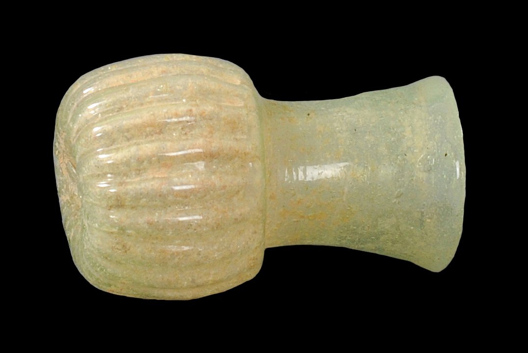 ANCIENT ROMAN LINED GLASS FLASK: Features an indented bottom. The base part has a lovely vertical-line style design. A unique type of flask. Circa 1st-2nd Century A.D.Measurements: 2 1/2 in. H. (6.4 cm.)Ex: Prominent European collect