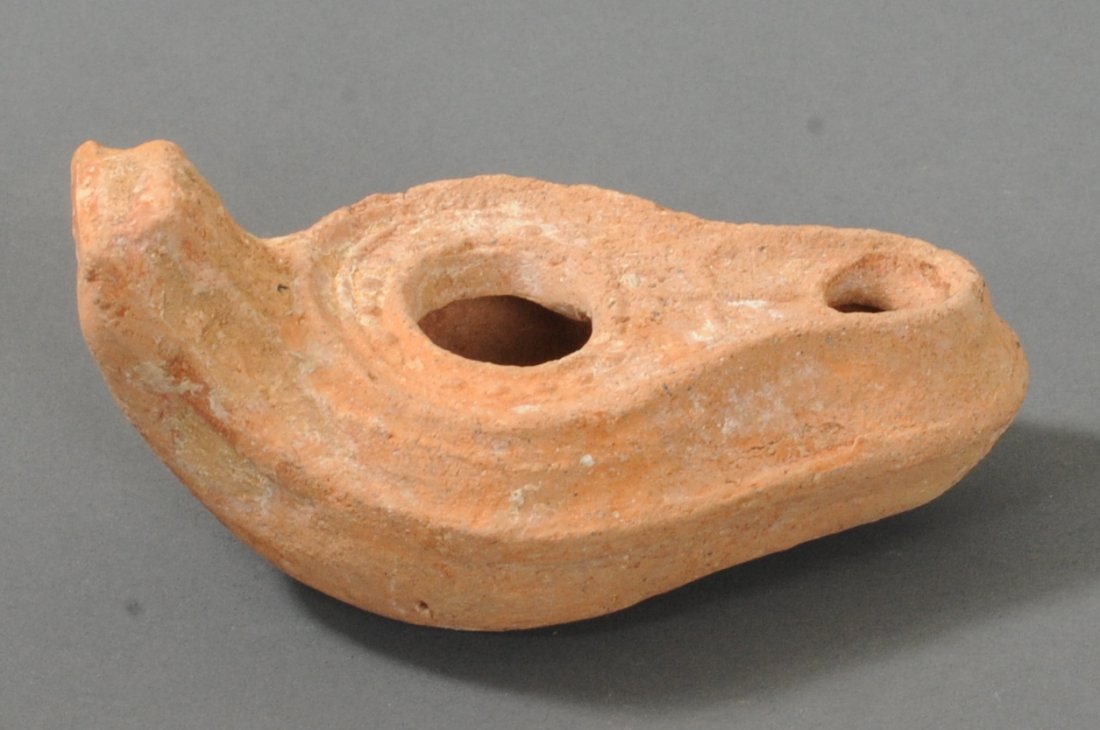 ANCIENT BYZANTINE DECORATED POTTERY OIL LAMP: Decorated with a cross next to the nozzle. Features some nice circular designs near the discus. Has vertical line designs near the thumb rest. Stamper's mark of five concentric circles on the bottom.C