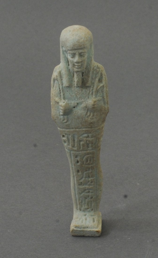 ANCIENT EGYPTIAN TEAL FAIENCE USHABTI WITH INSCRIPTIONS: With a vertical line of hieroglyphics, standing mummiform. Circa 600-300 B.C. Measurements: 4 1/2 in. H. (11 cm.) Ex: Important German private collection of Egyptian works, 1970's; Ex: German art mark