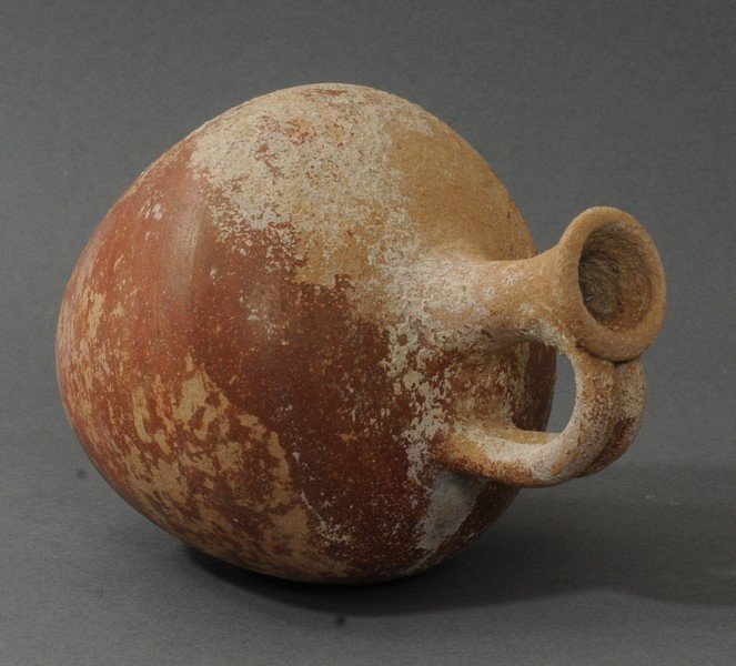 APHRODITE AUCTION #3-RED GLAZED SINGLE HANDLED AMPHORA: Circa 800-600 B.C. Measurements: 6 5/8 in. H. (18.8 cm.) Ex: Prominent French private collection, 1970s. Ex: European art market, 1980s; Ex: New Jersey private collection, 1990s. Single handed, with a