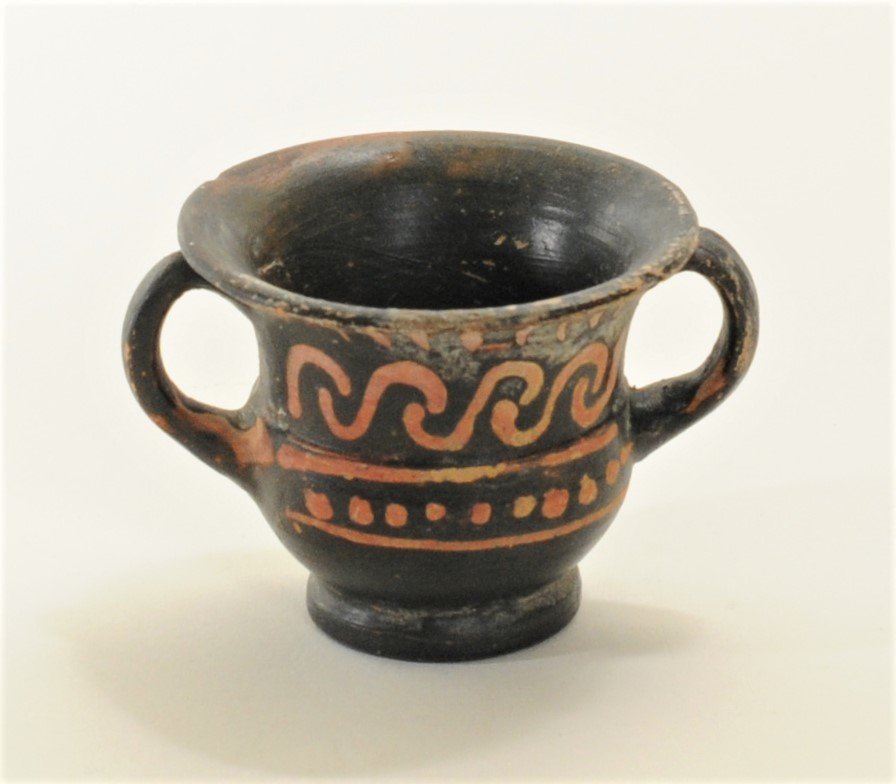 Aphrodite Gallery - Apulian Miniature Skyphos: South Italian, Apulian, ca. 350 - 330 B.C. A decorated skyphos with footed base from Apulia, A Greek colony in South Italy, Decorated in red paint with scroll pattern above a register od dotted line a