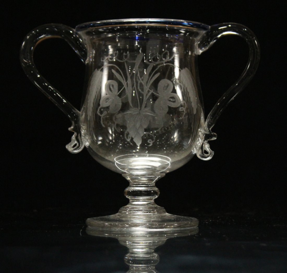 Hand blown glass trophy: Hand blown glass trophy with blue rim, glass has etched or cut decorations . Size: 6.5 h , 8 w