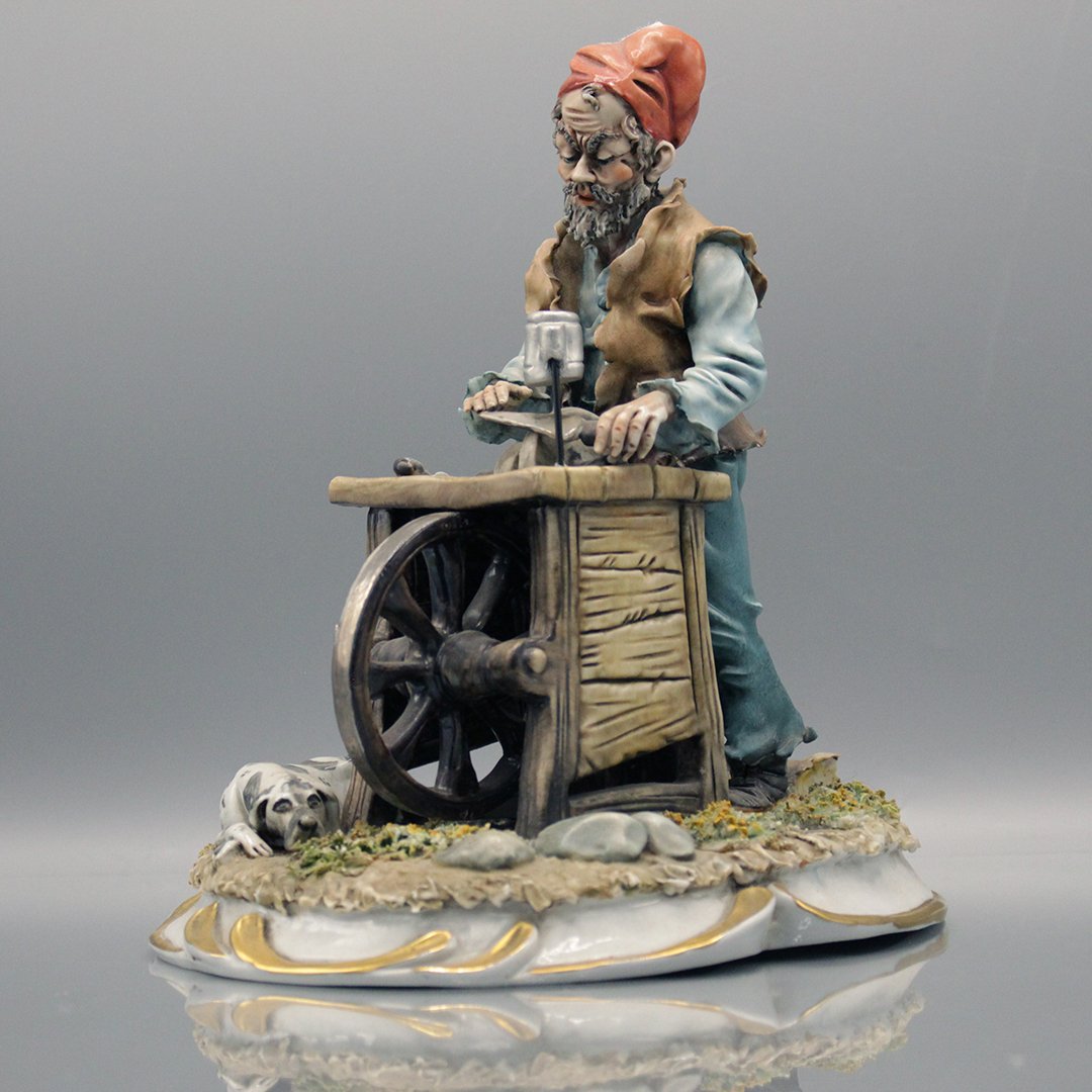 CAPODIMONTE Porcelain Knife Sharpening Figure: CAPODIMONTE Porcelain Knife Sharpening Figure. Size: 9.5 x 9 inches