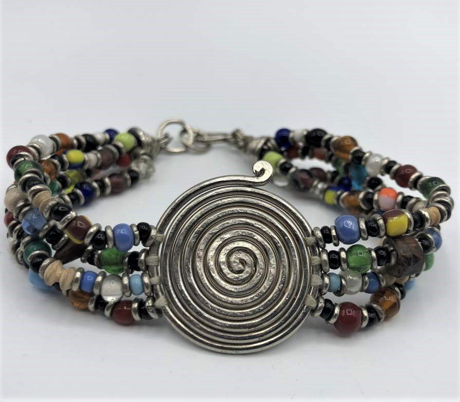 Manner of Alexander Calder, Silver Wire Bracelet: Manner of Alexander Calder, Silver Wire Bracelet with beads. Size: round silver swirl 1 1/8 in. x 1 in.; 4 strands of multi color beads; bracelet diameter 2.5 in.