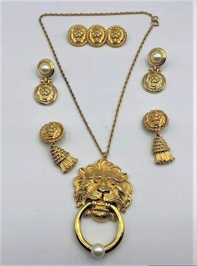 4 Piece Lion Costume Set Necklace [2] Earrings Brooch: 4 Piece Lion Costume Set Necklace [2] Earrings Pin in gold tone. Size: Lion pendant 4 in. x 2.5 in.; chain 20 in. length; earrings pearl 2 in. x 1 in. ; earrings tassel 2.25 in. x 1 in. ; Brooch 2.75 