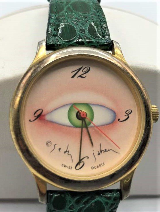 Seth Jaben EYE Wristwatch Made by Aubrey Freres: Novelty watch with eye illustration by Seth Jaben and made by Aubrey Freres through Roland Marketing. Leather emerald green watchband. Size: bezel 1 3/8 in.