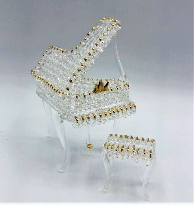 Hand Blown Glass Baby Grand Piano and Bench Figurine: Hand Blown Glass Baby Grand Piano and Bench Figurine. Clear glass with gold accents. Size: piano 4.75 in. height, 3 in. length, 2.5 in. wide; bench 1.5 in. height, 1.5 in. length, 1 in. wide