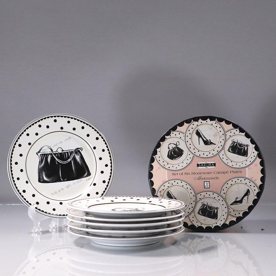 [6] Six Sakura Stoneware Canape Plates in Original Box: [6] Six Sakura Stoneware Canape Plates in Original Box. Poket books and shoes motife. Size: 6 in. height box x 6 in. wide