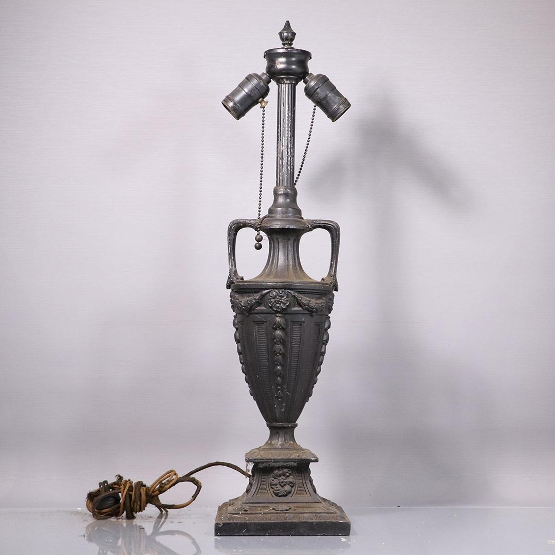 Antique Metal Urn Lamp Base for a Panel Shade: Antique Metal Urn Lamp Base for a Panel Shade. Original dark patina finish. Lamp complete with original finial, needs rewiring. Size: 25 in. height x 6 in. wide