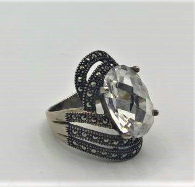 .925 Sterling Ring Large Faceted Crystal & Marcasites: .925 Sterling Silver Ring Large Faceted Crystal Center Stone & bands of Marcasites surrounding. Ring size: 7.25