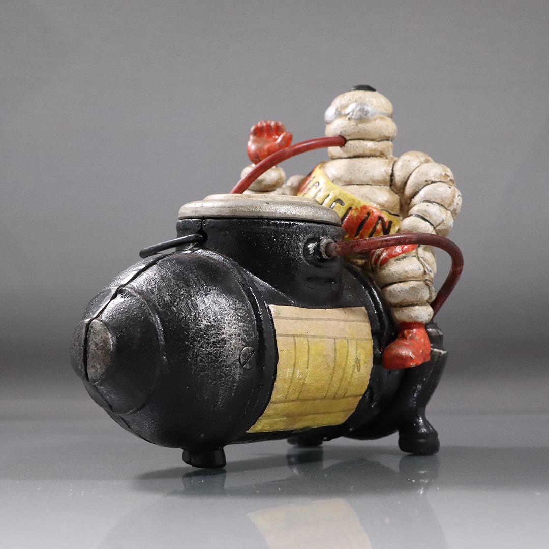 Michelin Man Cast Iron Figure Sitting on Compressor: Michelin Man Cast Iron Figure Sitting on Compressor. Original paint finish. size: 7.5h x 7.5L x 4.5w