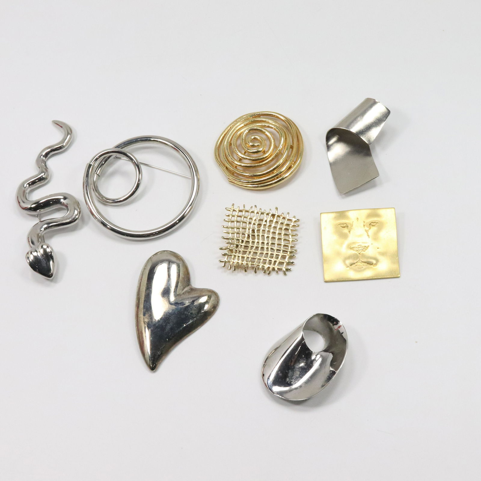[8] Assorted Modern Design Brooches Silvertone Goldtone: [8] Assorted Modern Design Brooches Silvertone Goldtone. Sizes: 5 in. x 1 3/4 in. ; 3 in.; 2 1/4 in. x 2 in. ; 3 1/4 in. x 2 1/8 in. ; 1 7/8 in. ; 2 in. x 1 3/4 in. ; 2 3/8 in. ; 1 3/4 in. x 1 7/8 in.