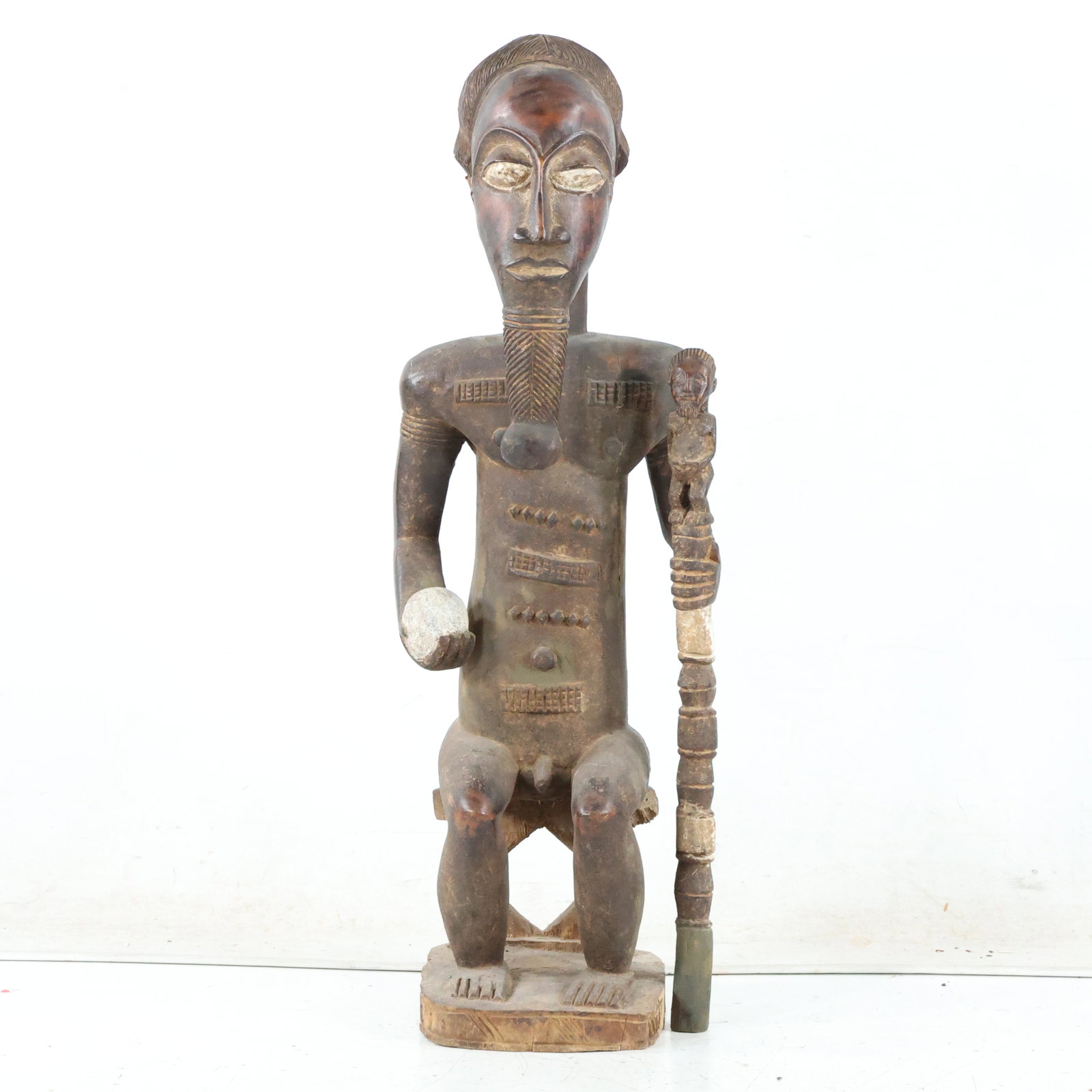 Antique African Wood Sculpture Seated Man Holding Shaft: Antique African Wood Sculpture Seated Man Holding Shaft. Original patina finish. Size: 28 x 7